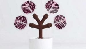 Árvore com painel que capta energia solar em suas "folhas" criada a partir de impressão 3D. Tronco marrom e folhas roxo com rosa.