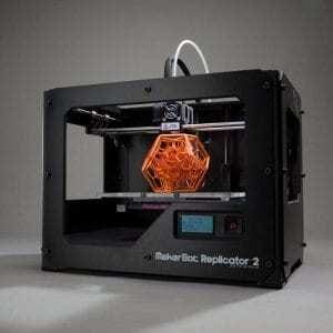 Impressora 3D da marca Makerbot com peça sendo impressa no centro. Continue lendo nosso post.